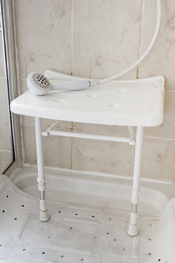 White Plastic shower seat used by the elderly and disabled to aid them by allowing them to sit and wash often reccommended by occupational therapists
